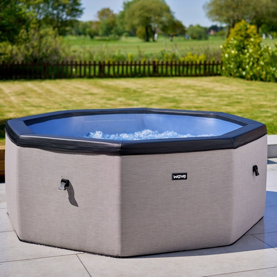 Como 6 Person Eco Foam spa in light grey showing wave logo in middle and bubbles inside the hot tub.