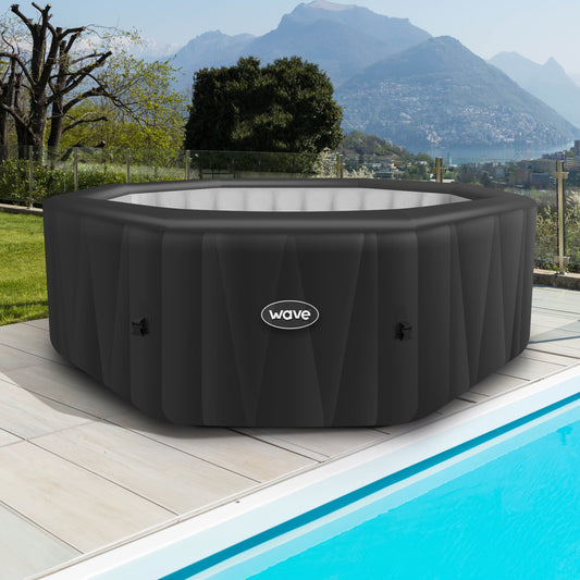 Aegean grey inflatable hot tub from Wave Spas inflated next to swimming pool.